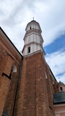 Tuğladan yapılmış tarihi bir kilise kulesinin çarpıcı manzarası canlı, mavi bir gökyüzüne karşı kurulmuş. Mimari, tarih, din veya kültür mirasıyla ilgili projeler için ideal.