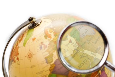 Seçici odak, beyaz arka plandaki büyüteçten dünyaya bakmak. Öğrenme, öğrenim, eğitim ve araştırma kavramı.