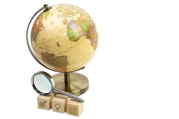 Tahta küp ve büyüteç üzerine sembol eğitimi almış bir Globe. Öğrenim, öğrenim, bilgi ve eğitim kavramı.