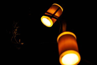 Ağaçtan sarkan parlak fenerlerin olduğu büyüleyici bir gece sahnesi yumuşak parıltılarıyla sıcak ve büyüleyici bir ortam yaratıyor..