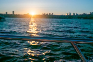 İstanbul Boğazı 'nın üzerinde çarpıcı bir günbatımı var. Gökyüzü turuncu ve pembe sıcacık renklerle parlıyor. Suyun ve şehrin üzerine güzel bir parıltı saçıyor..