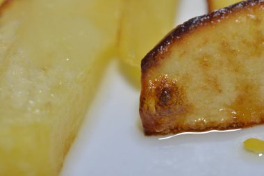 Bu klasik konforlu yemeğin nefis çıtır çıtır dokusunu ve ağız sulandıran görüntüsünü yakalayan altın ve çıtır patateslerin fotoğrafı..