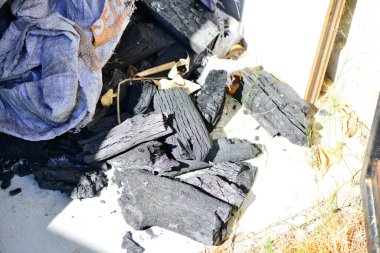 Bu geleneksel enerji kaynağının ham ve dokulu özünü yakalayan loş bir kömür mahzenindeki siyah kömür yığınının cesur ve yakın plan görüntüsü..