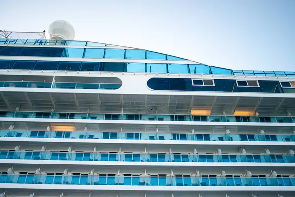 İstanbul Boğazı 'nın manzaralı zeminine karşı kurulu büyük bir yolcu gemisinin pencere ve balkonlarının ayrıntılı bir görüntüsü, denizcilik lüksü ve kentsel zarafeti yansıtıyor..
