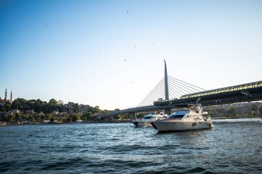Istanbuls Boğazı ve Hali 'nin manzaralı güzelliğini yansıtan bir fotoğraf, canlı şehir manzarasını, köprüleri ve hareketli rıhtımı gözler önüne seriyor.