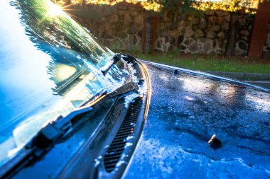 Sabahın erken saatlerinde bir SUV aracının yüzeyindeki erimiş buzu yakalayan bir fotoğraf, buz kalıplarını ve erime etkisini gösteriyor..