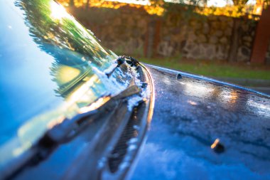 Sabahın erken saatlerinde bir SUV aracının yüzeyindeki erimiş buzu yakalayan bir fotoğraf, buz kalıplarını ve erime etkisini gösteriyor..