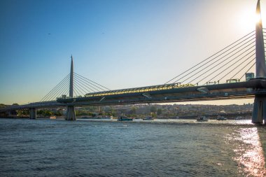 Istanbuls Boğazı ve Hali 'nin manzaralı güzelliğini yansıtan bir fotoğraf, canlı şehir manzarasını, köprüleri ve hareketli rıhtımı gözler önüne seriyor.