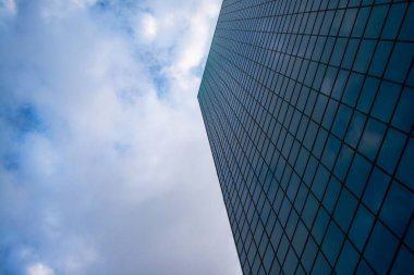 A skyscraper reaching into the clouds and fog, creating an atmospheric and ethereal view of modern urban architecture. clipart