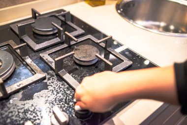 Fırını yakmaya çalışan bir aşçı, yemek pişirme sürecinin ortasında fırını yakma eylemini sergiliyor..