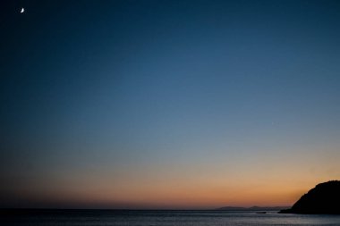 Huzurlu denizin üzerinde ay yükselirken gizemli bir alacakaranlık beliriyor. Alacakaranlığın dingin kucağında kıyı sularında büyüleyici bir parıltı yayıyor..