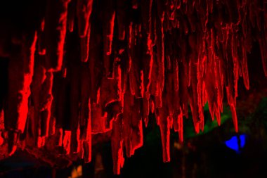 Journey through a vibrant cave adorned with colorful walls, stalactites, and stalagmites, revealing the underground beauty of nature's geological wonders. clipart