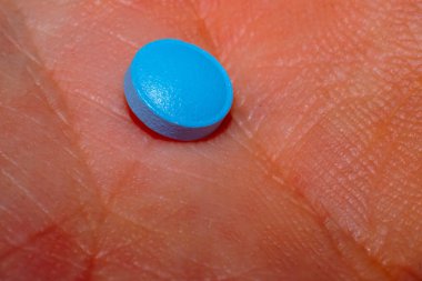 A close-up macro photo capturing the intricate details of a blue pill, representing pharmaceutical care for health and wellness clipart