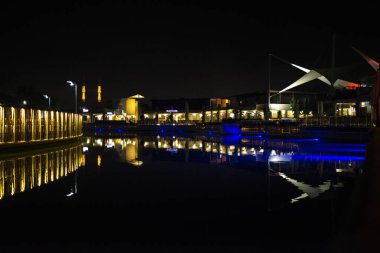 A captivating night view of Turgutreis Marina in Bodrum, where lights dance on the waterfront, creating a scenic and tranquil Turkish coastal atmosphere clipart