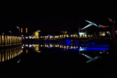 Işıkların limanda dans ettiği Bodrum 'daki Turgutreis Marina' nın büyüleyici bir gece görüntüsü, Türk kıyı şeridinde manzaralı ve sakin bir atmosfer yaratıyor.