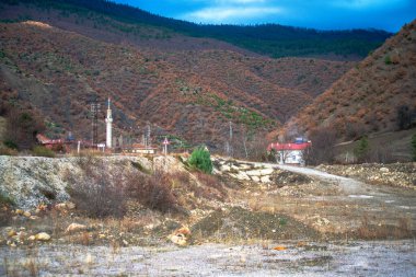 Köydeki uzak bir cami, geleneksel mimariyle kırsal güzelliğin sükunetini harmanlayan huzurlu ve ruhani bir sığınak olarak duruyor..