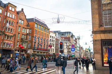Amsterdam Kubbe Meydanı Noel ışıklarıyla canlanıyor, insanlarla dolu neşeli bir cadde, tatil sezonunun neşeli atmosferini yakalıyor..