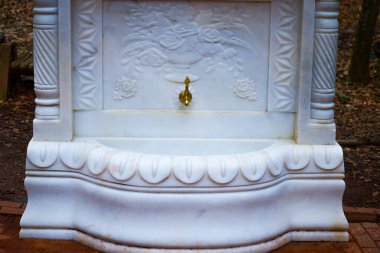 A luxurious golden fountain tap adorned with intricate white marble designs, exuding elegance and opulence. clipart