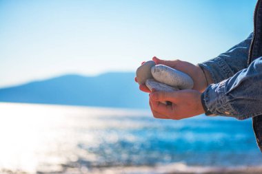 Kıyıdaki esinti taşlarının arasında uyumu bul narin bir şekilde dengeli bir deniz manzarası.