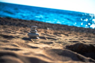 Find harmony amidst the coastal breeze  stones delicately balanced atop each other, a serene spectacle by the sea clipart