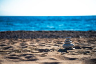 Kıyıdaki esinti taşlarının arasında uyumu bul narin bir şekilde dengeli bir deniz manzarası