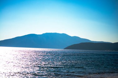 Kendinizi sakin mavi denizin kumlu kıyı şeridiyle buluştuğu sakin kıyı şeridinin güzelliğine daldırın..