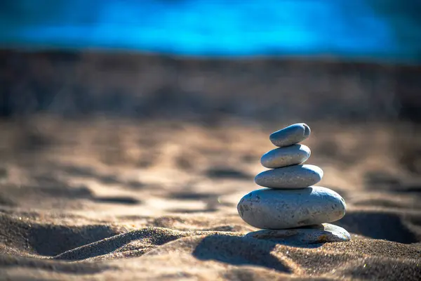 Kıyıdaki esinti taşlarının arasında uyumu bul narin bir şekilde dengeli bir deniz manzarası