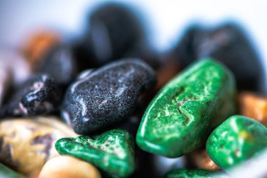 Renkli çakıl taşlı çikolataların makro fotoğrafı, bu eşsiz, eğlenceli ikramların canlı detaylarını ve leziz dokularını sergiliyor..