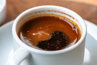 Türk kahvesinin ayrıntılı bir makro fotoğrafı zengin dokusunu, karmaşık köpüğünü ve derin, aromatik özünü gözler önüne seriyor..