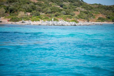 Uçsuz bucaksız mavi denizin nefes kesici manzarası, ufka doğru uzanıyor, sükunet ve sükunet hissi yaratıyor..