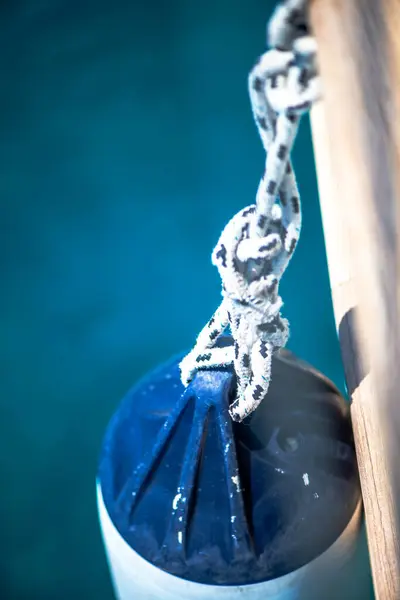 Gemiden sallanan bir çamurluğun yakın plan görüntüsü sağlam bir ip ve düğüm ile korunuyor. Geminin çarpışmasını önlemek için gerekli..