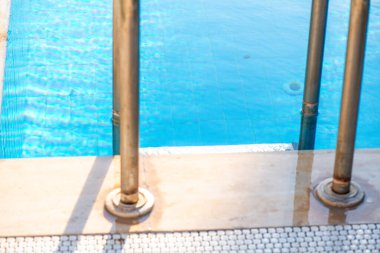 Parlak güneşin altında berrak bir havuzun berrak mavi suyunu gösteren canlı bir yaz fotoğrafı ferahlık ve rahatlama hissi uyandırıyor..