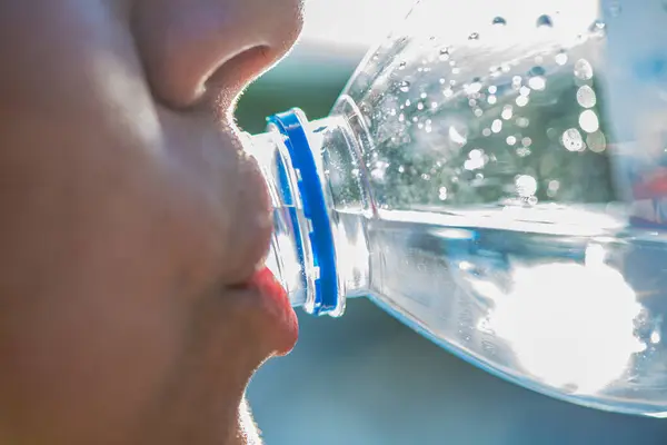 Bir kadının su içtiği anı yakalayan samimi bir makro fotoğraf canlandırıcı hareketlere, deri dokusuna ve canlı detaylarla damlacıklara odaklanıyor..
