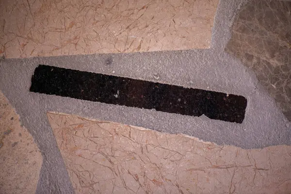 Mermer bir yüzey ve duvarın zarif dokusunu gösteren detaylı bir fotoğraf, yumuşak ışıklandırmada doğal damarları ve pürüzsüz taşları vurguluyor.