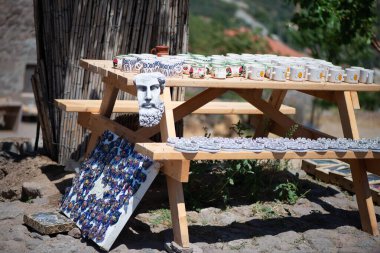 Geleneksel köy hatıraları koleksiyonu ahşap bir masa üzerinde zarif bir şekilde düzenlenmiş, el yapımı el sanatları, kırsal dekorasyonlar ve yerel hazineler sergileniyor..