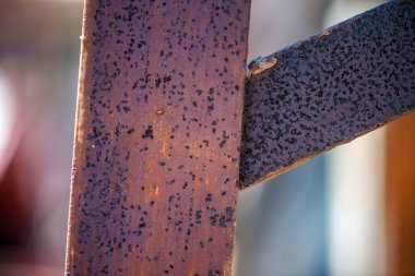 Paslı demirden yakın çekim. Detaylı dokuları, aşınmayı ve metalin yüzeyindeki eski aşınmayı gösteriyor..