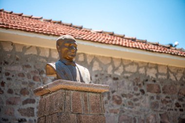 Filozofların bilge ifadelerini ve yaşlanmış taşın karmaşık dokularını vurgulayan bir Aristo heykelinin detaylı bir yakın çekimi.