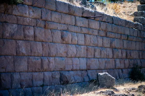 Eski bir amfi tiyatronun yıpranmış taş duvarlarının ve yapısal parçalarının yakın plan görüntüsü, ihtişamını ve klasik mimarinin kalıcı güzelliğini vurguluyor..
