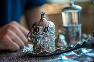 Geleneksel el yapımı Türk kahve fincanının, eski ve yıpranmış taş bir yüzeye yerleştirilmiş, detaylı ve atmosferik bir görüntüsü..