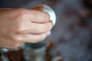 Geleneksel el yapımı Türk kahve fincanının, eski ve yıpranmış taş bir yüzeye yerleştirilmiş, detaylı ve atmosferik bir görüntüsü..