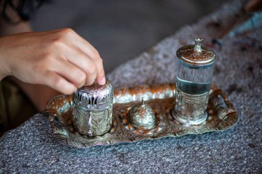 Geleneksel el yapımı Türk kahve fincanının, eski ve yıpranmış taş bir yüzeye yerleştirilmiş, detaylı ve atmosferik bir görüntüsü..
