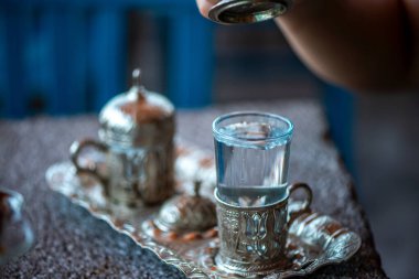 Geleneksel el yapımı Türk kahve fincanının, eski ve yıpranmış taş bir yüzeye yerleştirilmiş, detaylı ve atmosferik bir görüntüsü..
