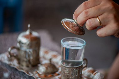 Geleneksel el yapımı Türk kahve fincanının, eski ve yıpranmış taş bir yüzeye yerleştirilmiş, detaylı ve atmosferik bir görüntüsü..