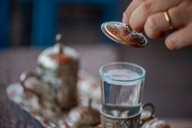 Geleneksel el yapımı Türk kahve fincanının, eski ve yıpranmış taş bir yüzeye yerleştirilmiş, detaylı ve atmosferik bir görüntüsü..