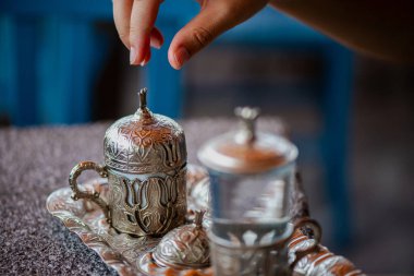 Geleneksel el yapımı Türk kahve fincanının, eski ve yıpranmış taş bir yüzeye yerleştirilmiş, detaylı ve atmosferik bir görüntüsü..