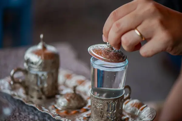 Geleneksel el yapımı Türk kahve fincanının, eski ve yıpranmış taş bir yüzeye yerleştirilmiş, detaylı ve atmosferik bir görüntüsü..