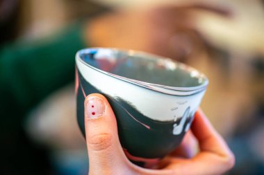 Yaratıcı bir atölyeden eşsiz bir seramik kahve fincanı. Kültürel ifade, yaşam boyu öğrenme ve modern eğitim ortamlarını vurgulamak.