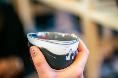 Yaratıcı bir atölyeden eşsiz bir seramik kahve fincanı. Kültürel ifade, yaşam boyu öğrenme ve modern eğitim ortamlarını vurgulamak.