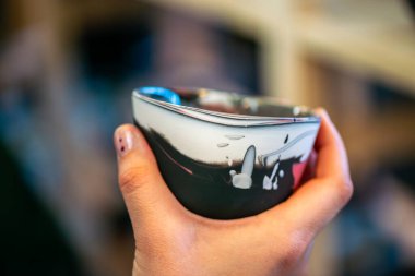 Yaratıcı bir atölyeden eşsiz bir seramik kahve fincanı. Kültürel ifade, yaşam boyu öğrenme ve modern eğitim ortamlarını vurgulamak.