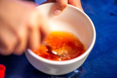 Domates ezmesini karıştıran, ev yemeğinin sıcaklığını ve leziz bir yemeğin dokusunu yakalayan bir kadının doğal mutfak sahnesi..